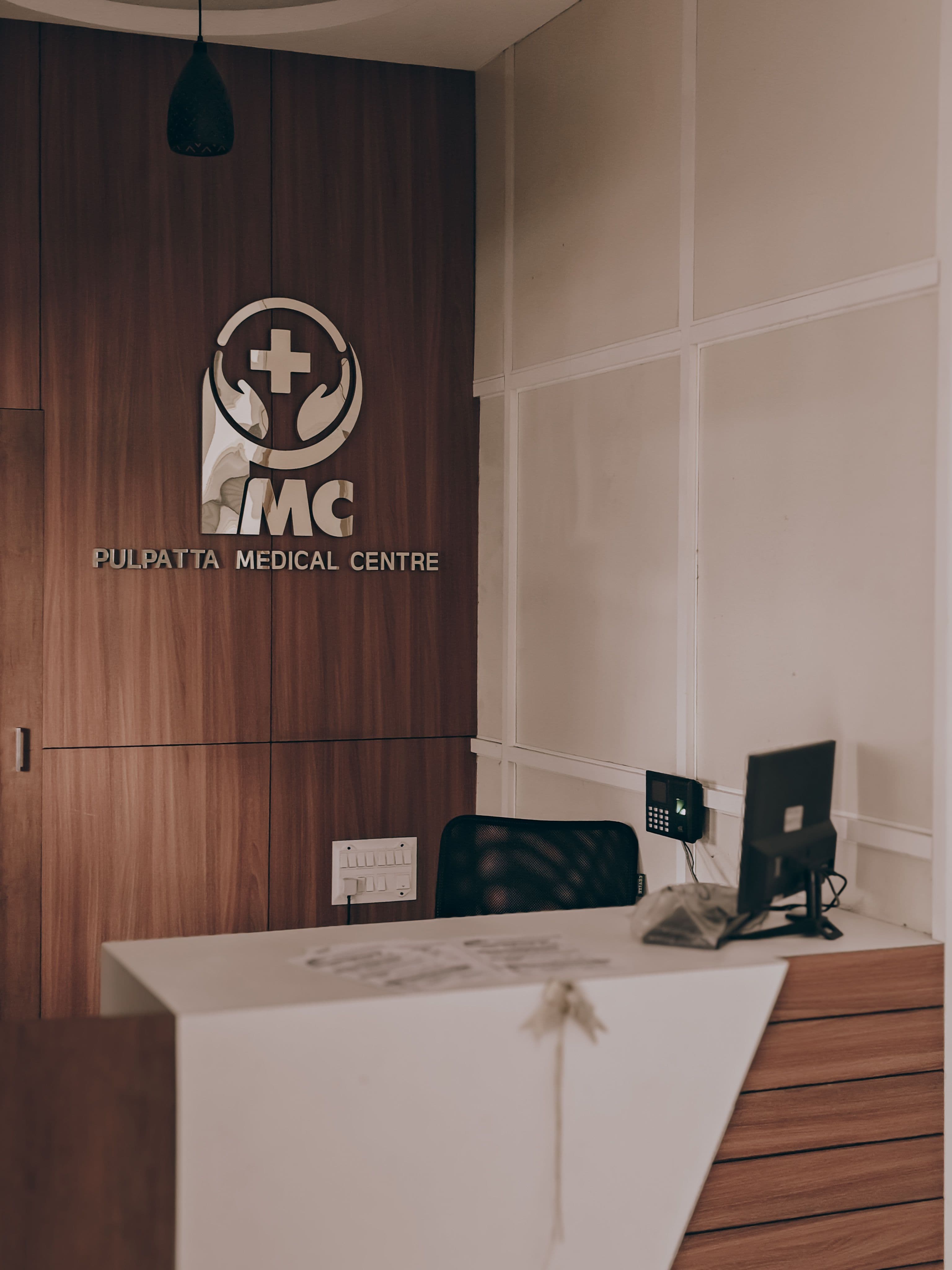 Meja resepsionis klinik dengan interior modern dan aksen kayu